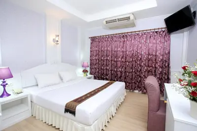 a hotel room with a bed and a tv at PJ Watergate Hotel in Bangkok