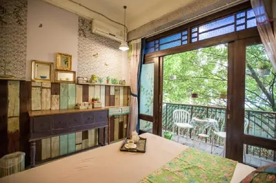 a room with a balcony with a table and a window at Phranakorn-Nornlen in Bangkok