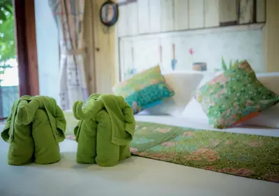 two green stuffed elephants sitting next to a bed at Phranakorn-Nornlen in Bangkok