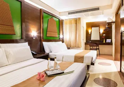 a hotel room with two beds and a desk at D&D Inn Khaosan in Bangkok