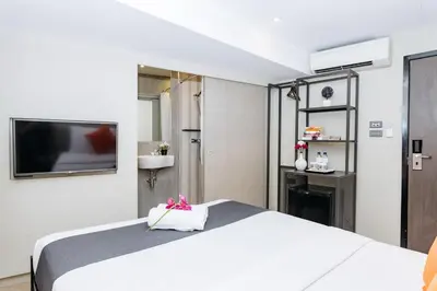 a bedroom with a white bed and a tv at Lucky House Khaosan in Bangkok
