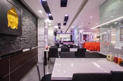 a restaurant with white tables and black chairs at Gusto Pratunam Hotel in Bangkok