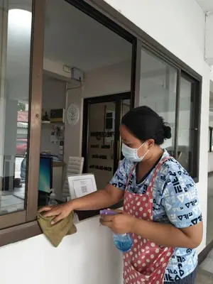 a woman wearing a face mask looking at her cell phone at The European Place in Bangkok