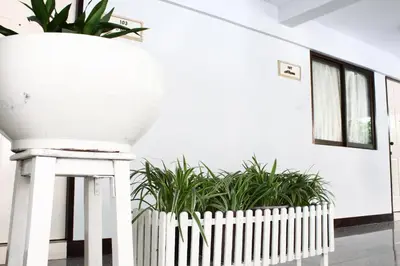 a white fence and plants in a room at The European Place in Bangkok