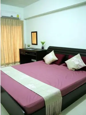 a bedroom with a large purple bed with a desk at The European Place in Bangkok