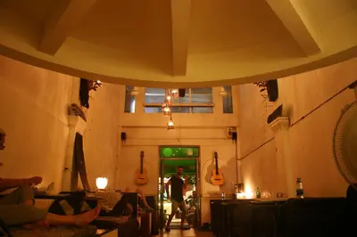 a room with guitars on the wall and a person standing in the doorway at Born Free Hostel in Bangkok