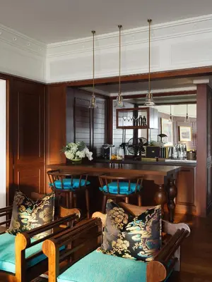 a kitchen with a bar with blue chairs and a table at Mandarin Oriental, Bangkok in Bangkok