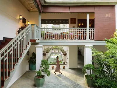 a woman walks through the lobby of a building at Mandarin Oriental, Bangkok in Bangkok