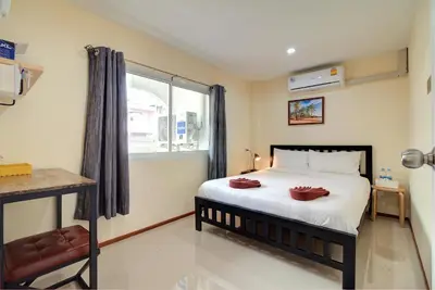 a bedroom with a large bed and a window at Red Pin Inn \u597d\u8fd0\u65c5\u9986 in Bangkok