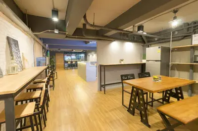 a room with tables and chairs and a kitchen at Red Pin Inn \u597d\u8fd0\u65c5\u9986 in Bangkok