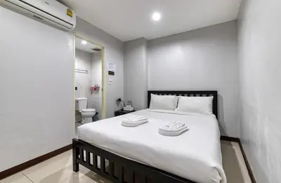 a bedroom with a bed with two towels on it at Red Pin Inn \u597d\u8fd0\u65c5\u9986 in Bangkok