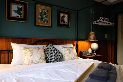 a bedroom with a white bed with green walls at TANA CASA 12 Large Sathorn 6BR Townhome with Parking in Bangkok