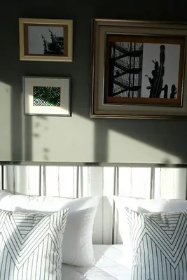 a bedroom with two white pillows and a picture on the wall at TANA CASA 12 Large Sathorn 6BR Townhome with Parking in Bangkok