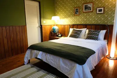 a bedroom with a bed with a green wall at TANA CASA 12 Large Sathorn 6BR Townhome with Parking in Bangkok