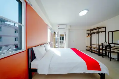 a bedroom with a red and white bed and a window at Salin Home Hotel Ramkhamhaeng in Bangkok