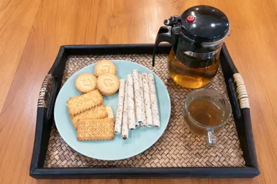 a tray with a plate of cookies and a drink at Timber Hostel in Bangkok