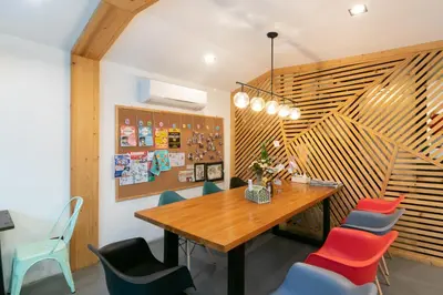 a dining room with a wooden table and chairs at Timber Hostel in Bangkok