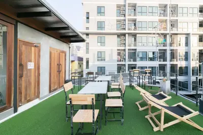 a balcony with tables and chairs on a building at Timber Hostel in Bangkok