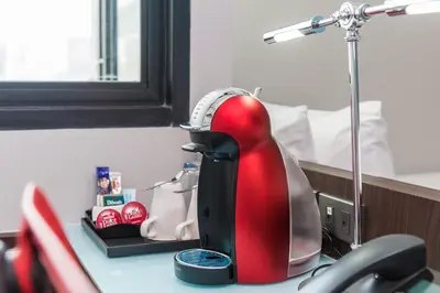 a red and black kettle on a desk with a lamp at Vib Best Western Sanam Pao in Bangkok