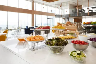 a counter topped with bowls of vegetables and other foods at The Quarter Ari by UHG in Bangkok