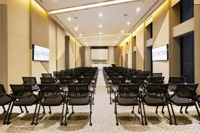 a room with a bunch of chairs and a projection screen at The Quarter Ari by UHG in Bangkok