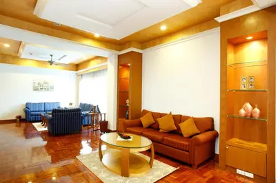 a living room with a couch and a table at Chaidee Mansion in Bangkok