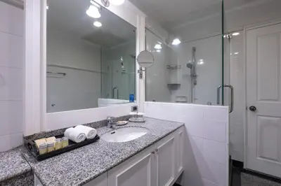 a bathroom with a sink and a large mirror at Cape House Hotel, Bangkok in Bangkok