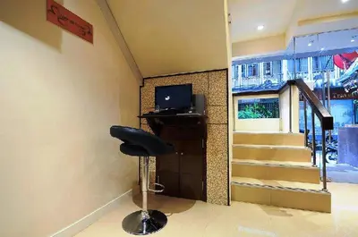 a room with a chair and a television and stairs at Royal Express Inn in Bangkok