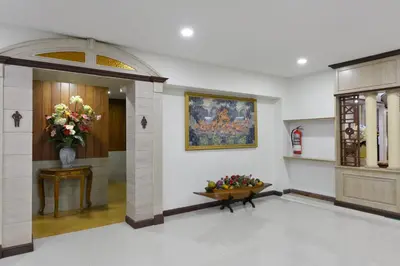 a lobby with a vase of flowers on a table at Nice Palace Hotel in Bangkok
