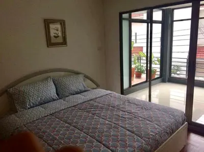 a bedroom with a bed and a large window at Nineplace 46 in Bangkok