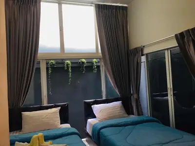 a room with two beds in front of a window at Nineplace 46 in Bangkok