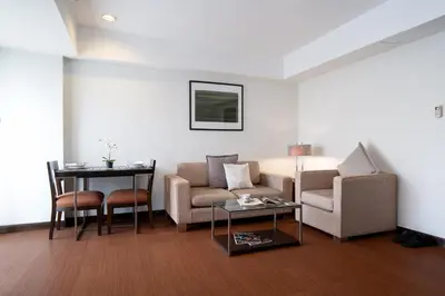 a living room with a couch and a table at Lily Hotel Bangkok in Bangkok