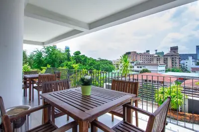 a table and chairs on a balcony with a view at Lily Hotel Bangkok in Bangkok