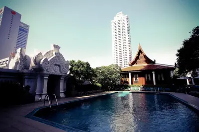 a swimming pool next to a building and a building at Indra Regent Hotel in Bangkok