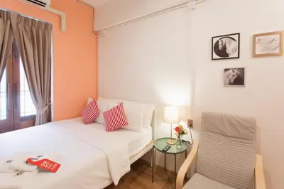 a hotel room with a bed and a chair at House Of PaPa Bangkok Siam in Bangkok