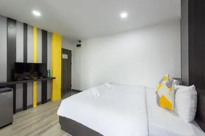 a bedroom with a white bed and a television at Riski Residence Bangbuathong in Nonthaburi