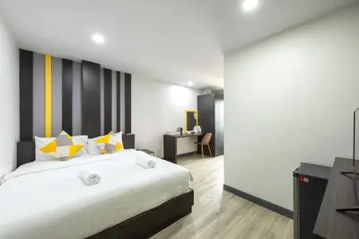 a bedroom with a large bed with yellow and white pillows at Riski Residence Bangbuathong in Nonthaburi