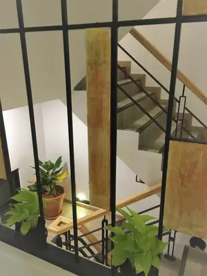 a metal spiral staircase with potted plants on a shelf at Bangkok Saran Poshtel in Bangkok
