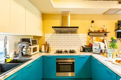 a kitchen with blue cabinets and a sink at Maneeya Park Residence in Bangkok
