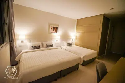 two beds in a hotel room with lights at Sleepstation at Pratunam in Bangkok