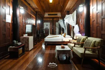 a bedroom with a bed and a couch and a table at Dhabkwan Resort in Nonthaburi