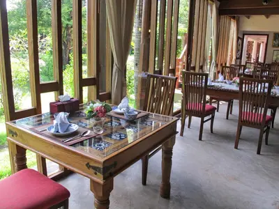a dining room with a table and chairs at Dhabkwan Resort in Nonthaburi