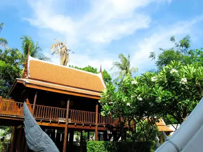 a building with a roof with trees in front of it at Dhabkwan Resort in Nonthaburi