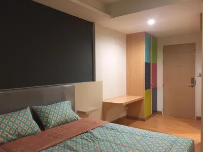 a bedroom with a bed and a rainbow wall at Nine Place Sukhumvit 40 in Bangkok