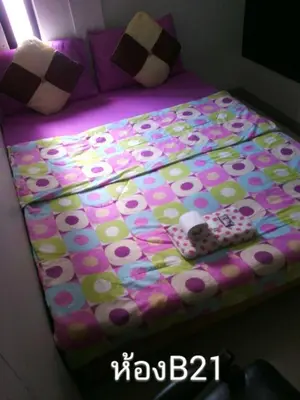 a bed with a polka dot blanket and a controller on it at Nine Place Sukhumvit 40 in Bangkok