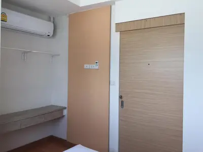 a wooden door in a room with a bench at Nine Place Sukhumvit 40 in Bangkok