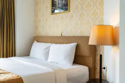 a hotel room with a bed and a lamp at Summit Pavilion Hotel in Bangkok