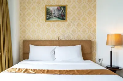 a bedroom with a bed and a painting on the wall at Summit Pavilion Hotel in Bangkok