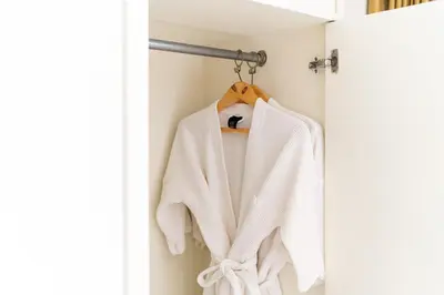 a white sweater hanging on a towel rack at Summit Pavilion Hotel in Bangkok