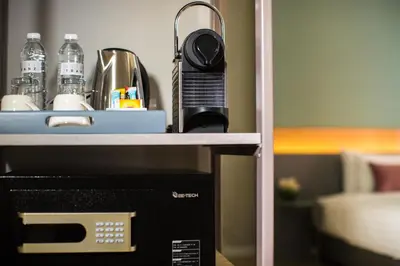 a microwave sitting on a shelf next to a counter at Hotel Tranz in Bangkok